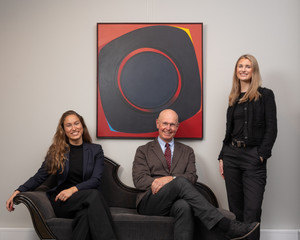 Maria Høy, Hans Richard Elgheim og Anna Stener fra Grev Wedels Plass Auksjoner foran et abstrakt maleri, i galleriets lokaler. Foto.
